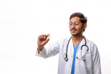 Fototapeta premium Young indian doctor holding pill in hand.