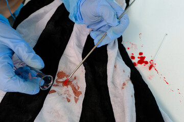 fresh splatter of blood on white table, stains on tissue at crime scene, blood sample collection...