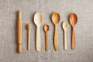 Wooden spoons made of natural wood on burlap fabric as a craft.