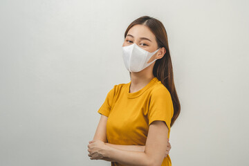 Portrait of attractive, pretty asian young woman, teenage wearing mask protect anti virus vaccine covid-19, influenza in yellow t-shirt. Health care prevention isolated on white background, copy space