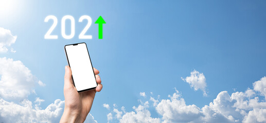 Hand hold 2021 positive icon on sky background.Plan business positive growth in year 2021 concept. Businessman plan and increase of positive indicators in his business, Growing up business concepts.