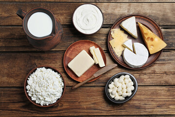 Fototapeta na wymiar Flat lay composition with dairy products and clay dishware on wooden table