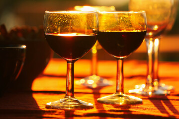 Red wine glasses on table with snacks background during the sunset