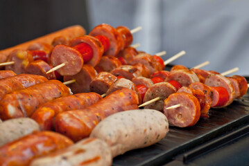 Sausages are fried on an electric grill. Different types of sausages close up.