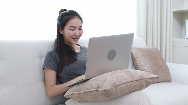 Woman sitting using laptop on sofa, Financial transactions and Internet security, Shopping with credit card.