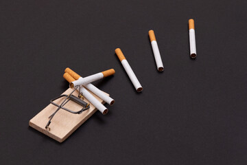 Tobacco Addiction and the World Corporation's Trap - Cigarettes in Wooden Mousetrap on Black Background