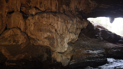 Fototapeta na wymiar Cave formations within the caverns of Mole Creek, in Tasmania, Australia. Limestone formations with varied lighting and cave river. 