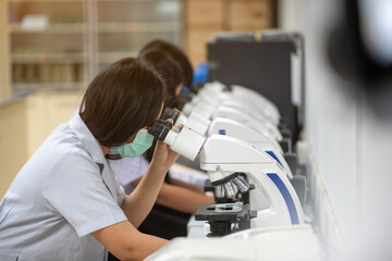 Scientists looking at the microscope