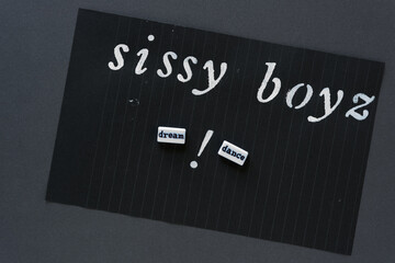 stencilled words "sissy boyz" with word beads "dream" and "dance" and a exclamation mark on black