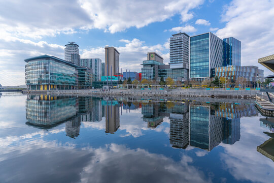 View of MediaCity and clouds reflecting in water in Salford Quays, Manchester, England