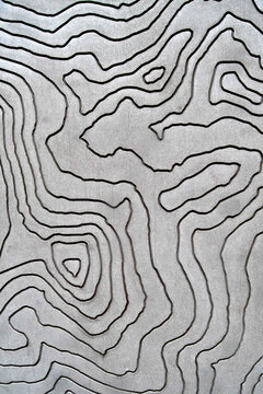Drilled lines on rock wall provide interest to bare wall and mimic lines on a topographic map, London, England 