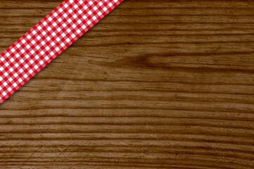 Fototapeta na wymiar Tischdecke rot weiß auf altem Holztisch als Hintergrund