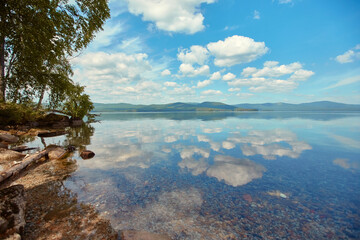 Lake Turgoyak. Russia. The Southern Urals. Clouds are reflected on the water surface of the lake