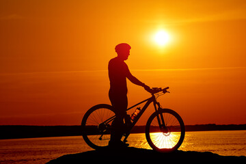 Silhouette of race cyclist. Shadow behind the sun of cycling man.