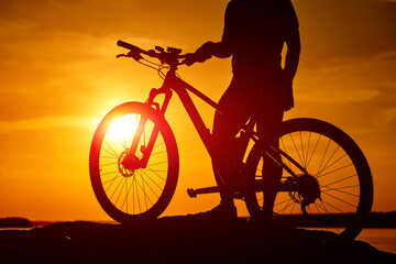 Sunset shadow of cycling man. Silhouette of evening biker.