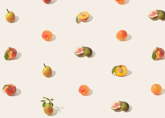 Summer fruit colorful texture made of ripe, juicy, peaches, apricots, pears and figs, isolated on pastel beige background. Minimal, natural plant food pattern. Sun and shadows. 