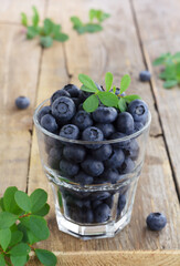 Fresh blueberries in a glass on wooden background