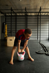 Naklejka premium Kid get ready to lift heavy dumbbell, preparing for exercise, watch posture and breathing. Work hard to become successful sportsman in future. Goal, dream, career, sport concept