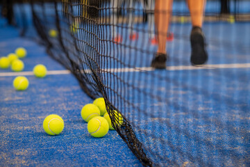 Tennis ball on the floor after a match - Padel balls - Yellow tennis balls in court on blue turf