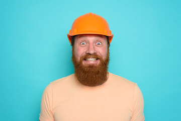 Worker with yellow hat is happy about his work. cyan background