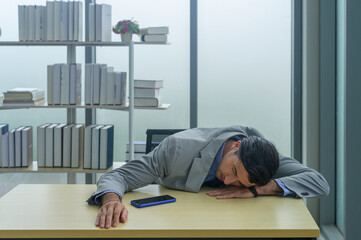 A young businessman tired and exhausted at work place.