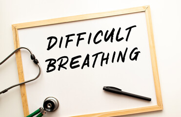 The text DIFFICULT BREATHING is written on a white office board. Nearby is a stethoscope.