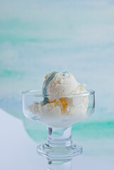 Ice cream in a glass bowl on a sea green background