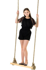 Joyful girl swinging on rope swing