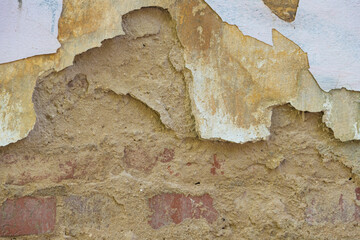 An old wall in a dilapidated house. Peeling plaster, background and texture
