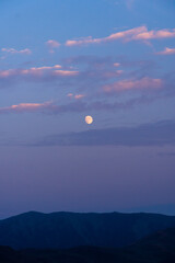Portrait of the moon  through clouds over the Sun Valley Idaho High Desert during Sunset