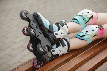 Fototapeta na wymiar Cropped close up of colorful rollerblades on childs legs
