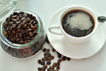 cup of black coffee and coffee beans, a piece of chocolate