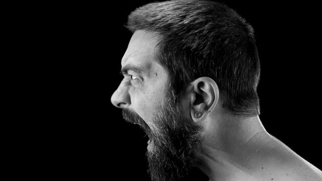 Man screams loud in slow motion, anger emotions and frustration. Black background