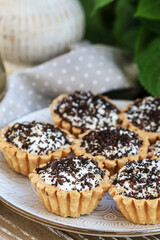 Tiny cupcakes with chocolate on the table.