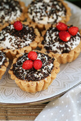 Tiny cupcakes with chocolate on the table.