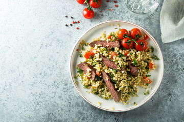 Couscous salad with grilled beef steak and herbs