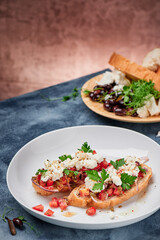 Beautiful bruschetta with feta cheese and tomatoes on a white plate. Space for text. High quality photo