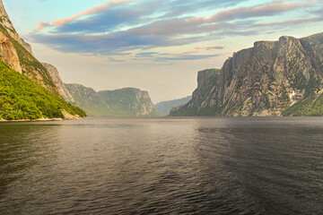 Admiring the beautiful view from the tour boat at the fjords of the Western brook pond in Gros Morne National Park, Newfoundland and Labrador, Canada - obrazy, fototapety, plakaty