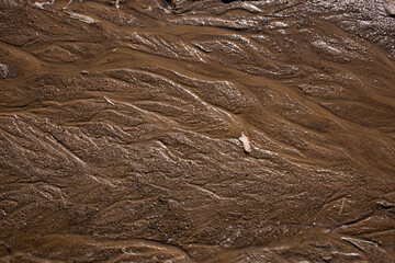 sand texture with wavy lines and jets of water in warm colors. Sand Surface After The Rain