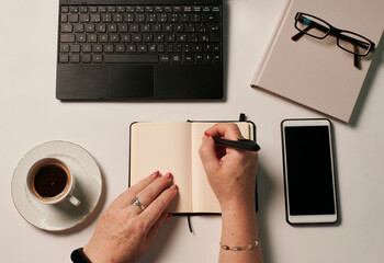 Business still live of an unrecognizable woman writing in a notebook