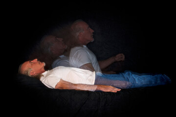 A unique multi flash image of man lying down and rising representing the soul leaving the body or...