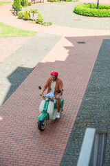 high angle view of african american man riding scooter on square
