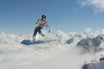 Flying snowboarder on mountains. Extreme sport.