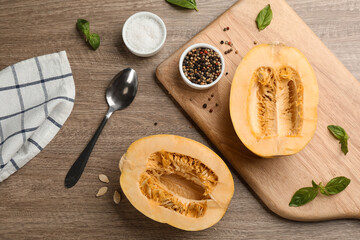 Flat lay composition with halves of fresh spaghetti squash on wooden table. Cooking vegetarian dish