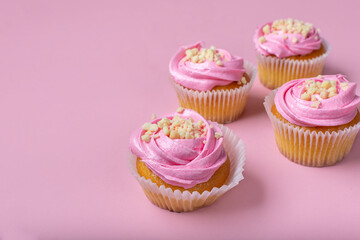 Cupcakes on a pink background. Cupcakes with yogurt and strawberry cream. Strawberry cupcakes.