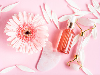 Obraz na płótnie Canvas Cosmetic beauty serum oil acid bottle product and quartz face roller guasha on pink background
