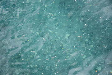 Calm and clear river water in gradient tones with sand and gravel on the bottom.