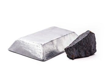 iron ore on isolated white background next to a polished steel ingot or bar, metals used in the...