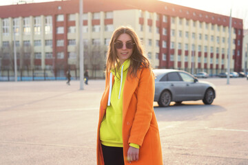 Lifestyle Portrait of cheerful brunette young woman in trendy colorful casual outfit looking over shoulder. Street Style. Good-looking Millennial Hipster Girl having fun sunny outdoors