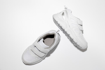 top view white unisex running shoes with velcro fasteners for easy footwear with hard shadows isolated on a white background.
